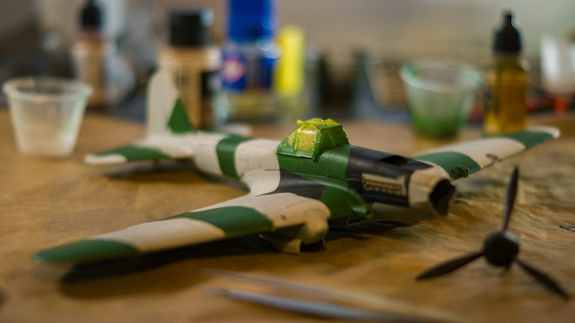 a green and white model airplane sitting on a table